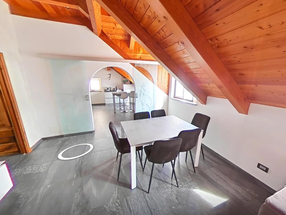 Soggiorno mansarda collegato alla cucina con travi in legno, tour 360 casa montagna