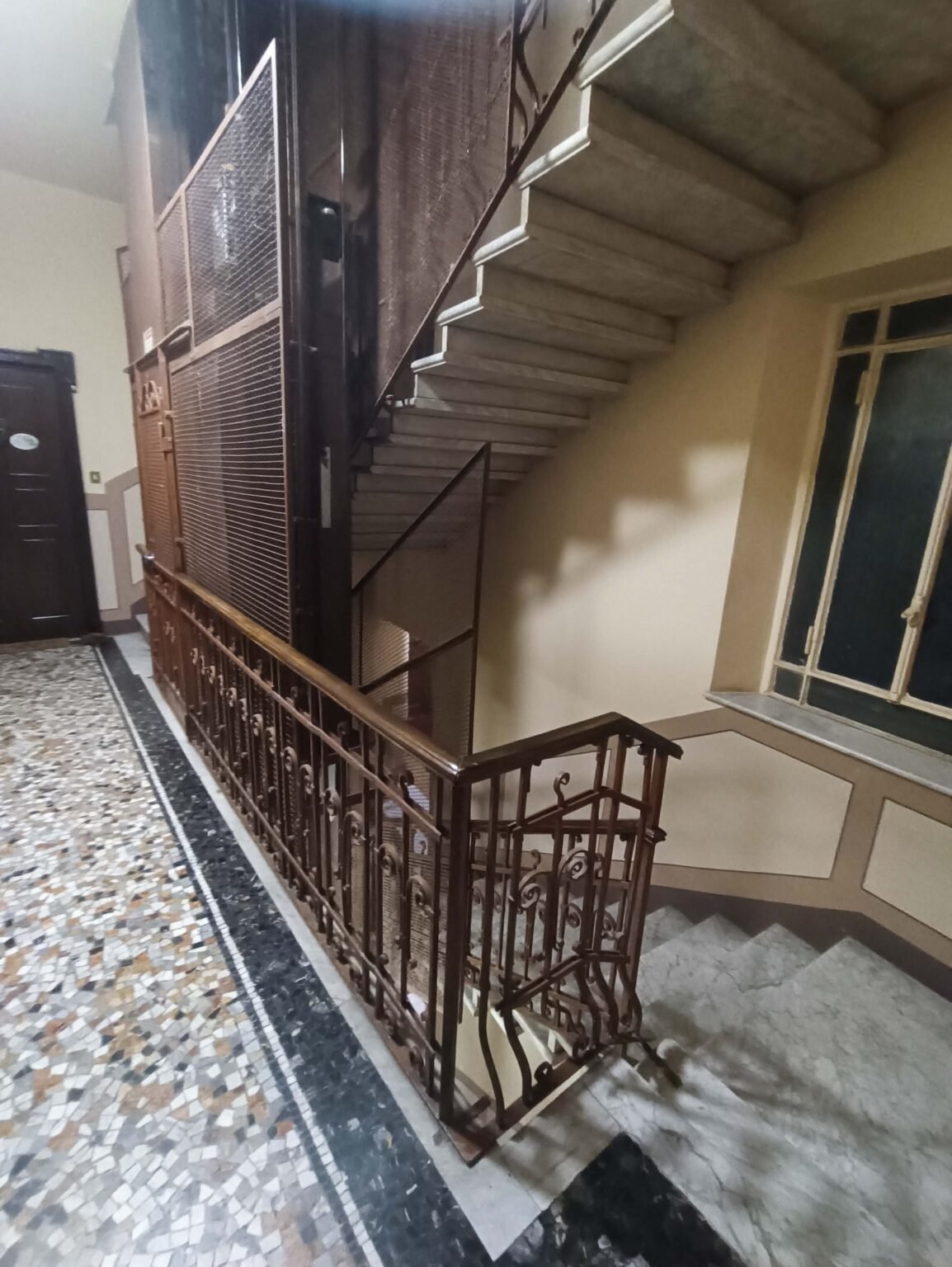 tromba scale edificio storico milano con parapetto in ferro e scala in marmo