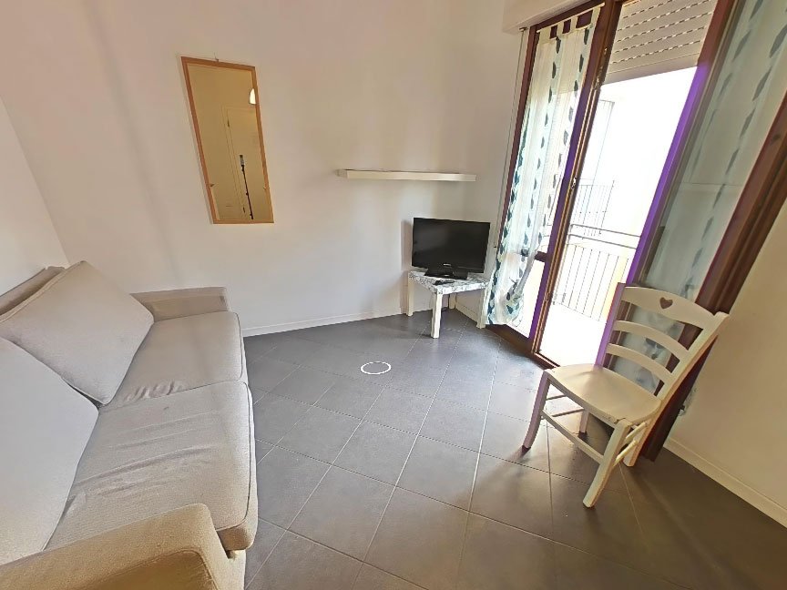 Zona giorno appartamento al mare con divano e accesso al balcone, tour 360 immobiliare